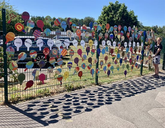 Balloons displayed on fence