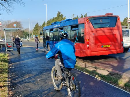 person riding a bike next to a bus