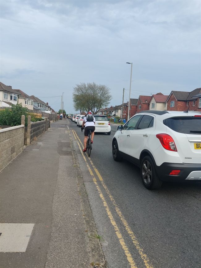 Cars driving past a cyclist