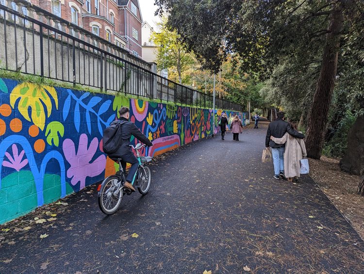 A cyclist and walkers walking along the new shared path in Upper Gardens