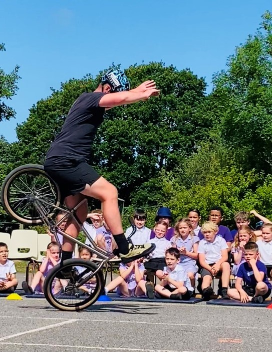 Matti Hemmings demonstrating one of his BMX tricks in front of schoolchildren